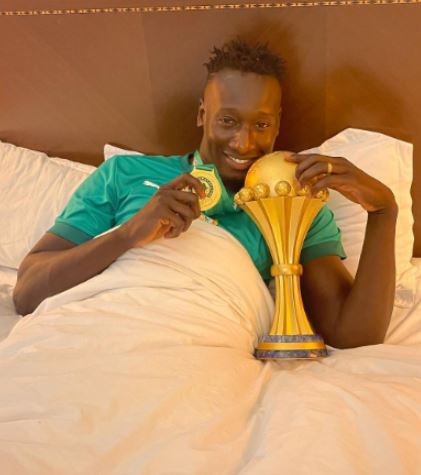 Famara Diedhiou holding over the cup of Africa Cup of Nations championship
